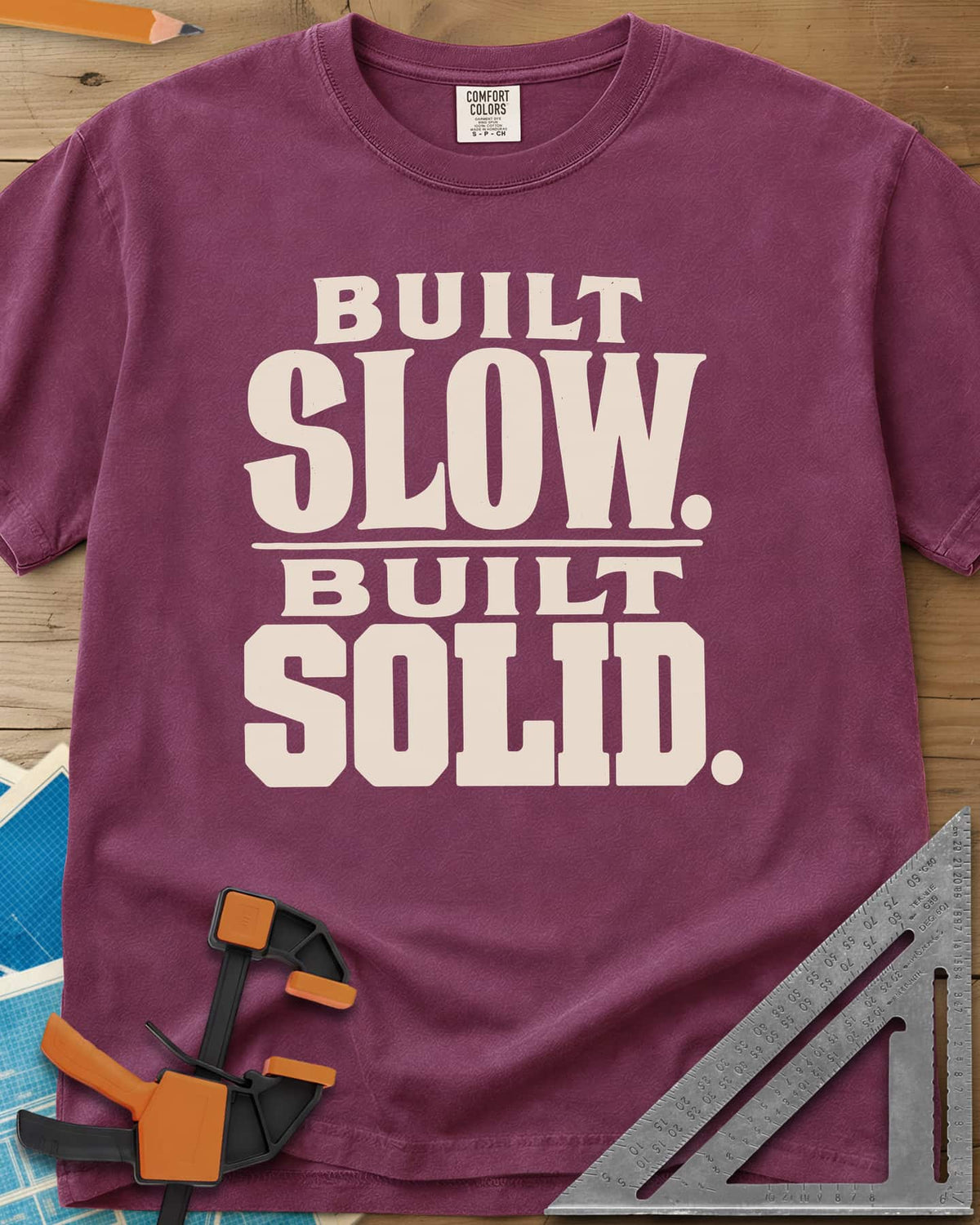 Built Solid heavyweight tee in Berry, bold stacked wood-type lettering, no graphic