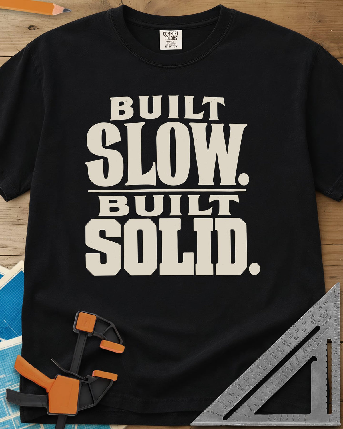 Built Solid heavyweight tee in Black, bold stacked wood-type lettering, no graphic