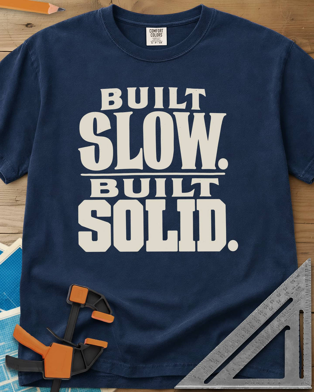 Built Solid heavyweight tee in Navy, bold stacked wood-type lettering, no graphic