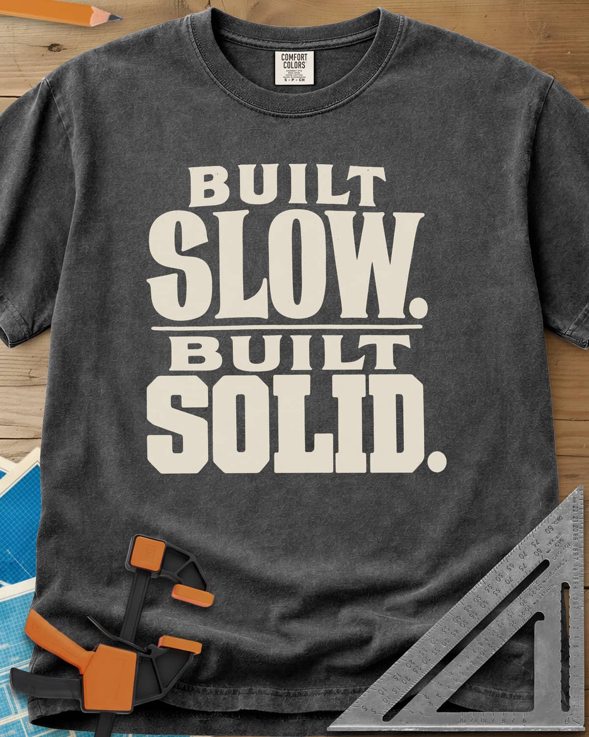 Built Solid heavyweight tee in Pepper, bold stacked wood-type lettering, no graphic
