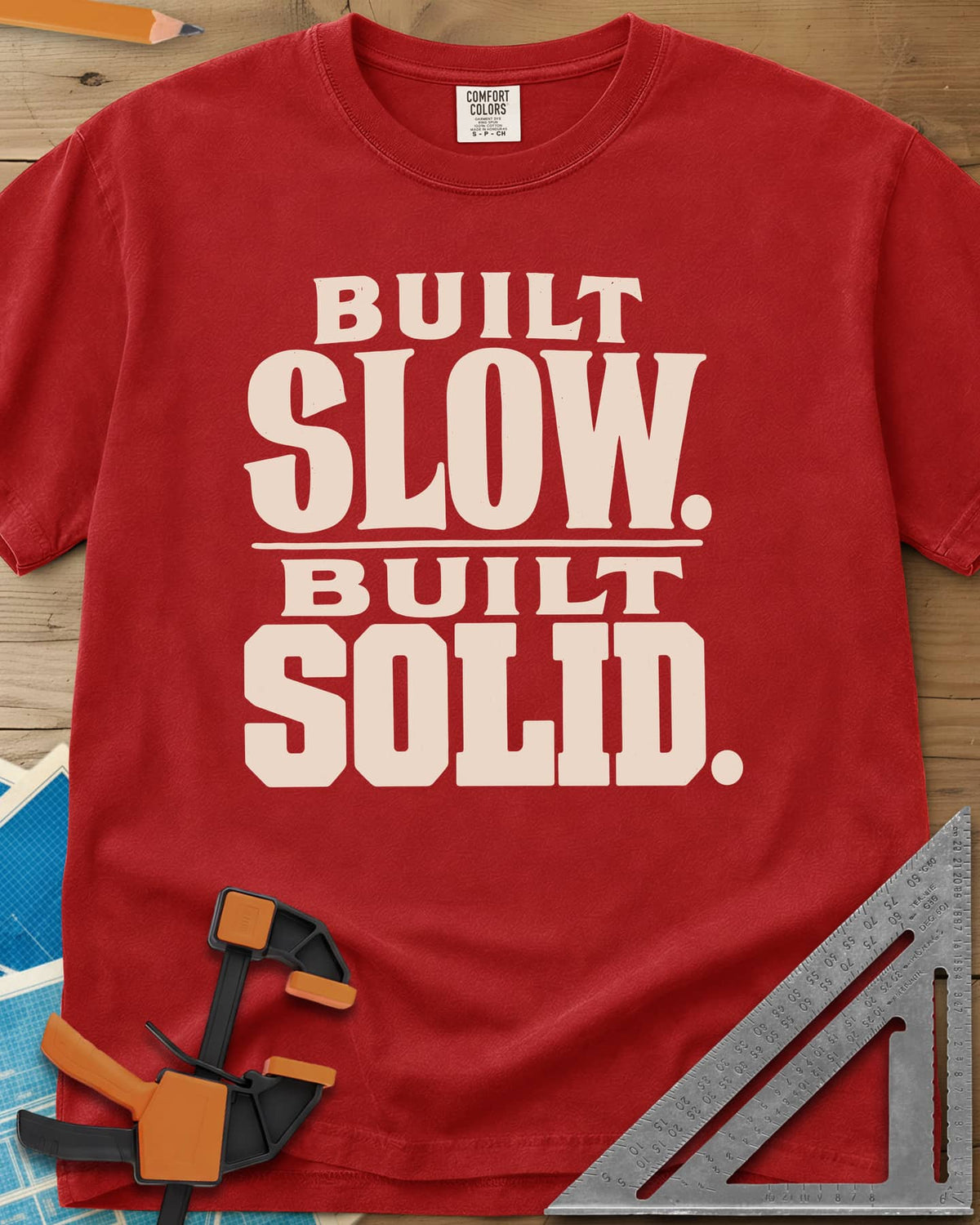 Built Solid heavyweight tee in Red, bold stacked wood-type lettering, no graphic
