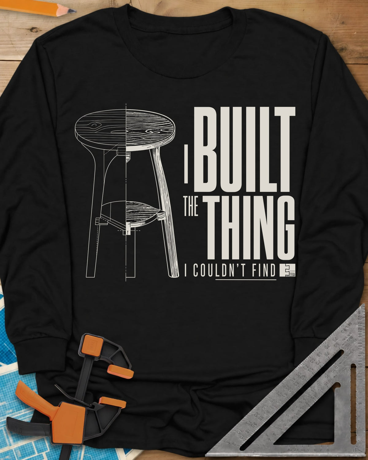 Built The Thing long sleeve shirt in Black, a three-legged stool drawn half blueprint, half wood grain