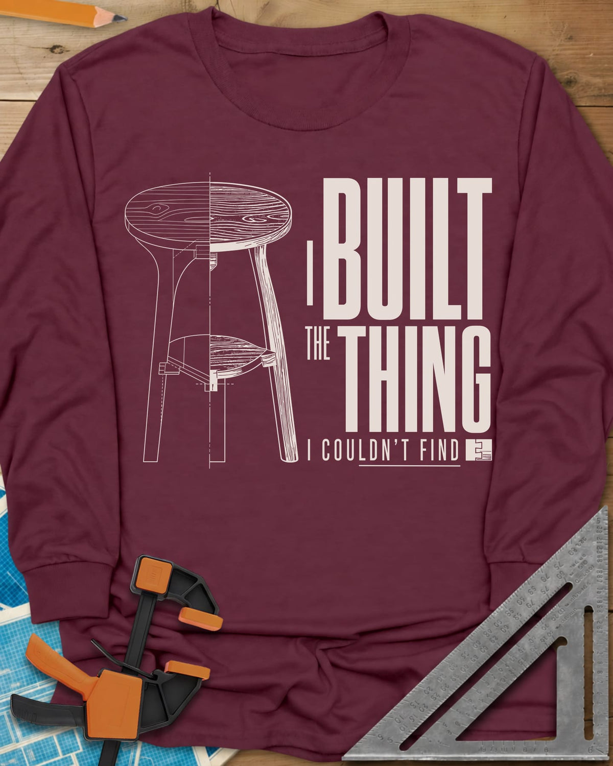 Built The Thing long sleeve shirt in Maroon, a three-legged stool drawn half blueprint, half wood grain