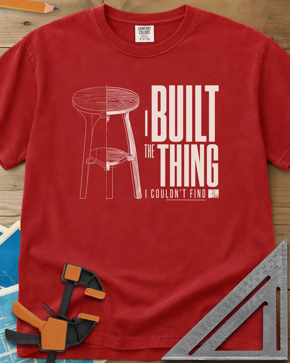 Built The Thing heavyweight tee in Red, a three-legged stool drawn half blueprint, half wood grain