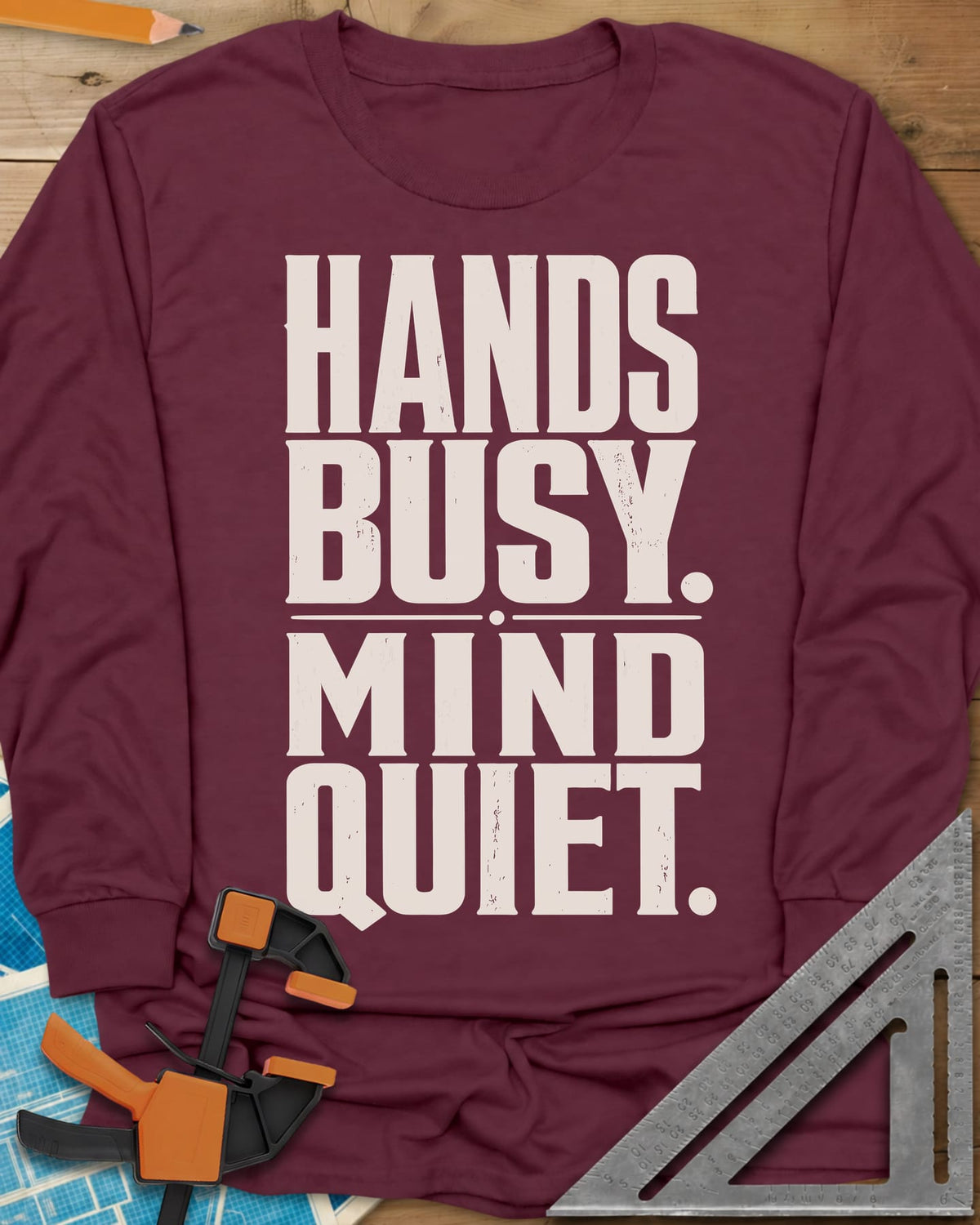 Busy Hands long sleeve shirt in Maroon, tall stacked block capitals with a dotted divider, no graphic