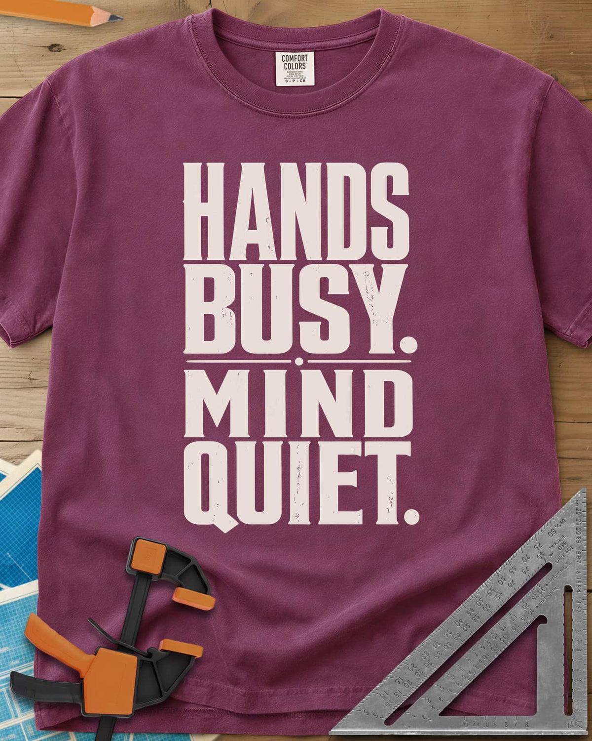 Busy Hands heavyweight tee in Berry, tall stacked block capitals with a dotted divider, no graphic