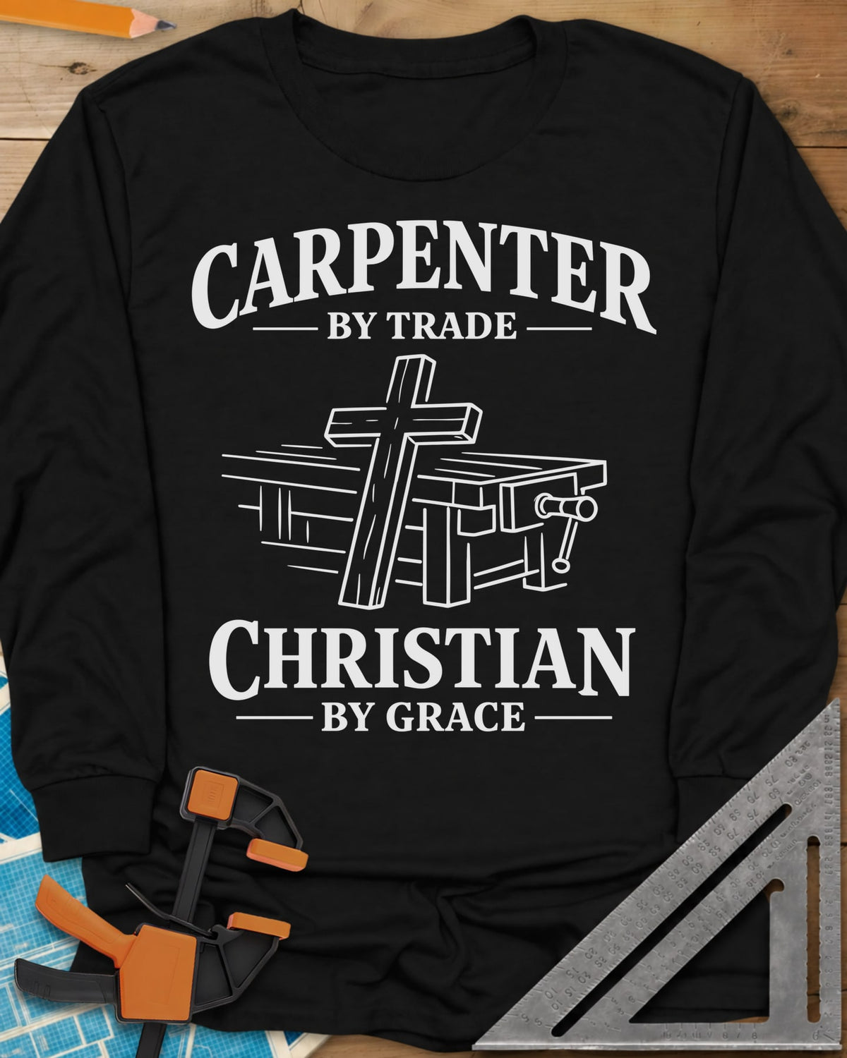Carpenter by Trade long sleeve shirt in Black, a wooden cross leaning against a workbench with a vise