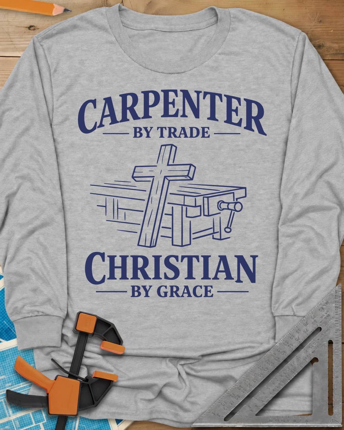 Carpenter by Trade long sleeve shirt in Sport Grey, a wooden cross leaning against a workbench with a vise
