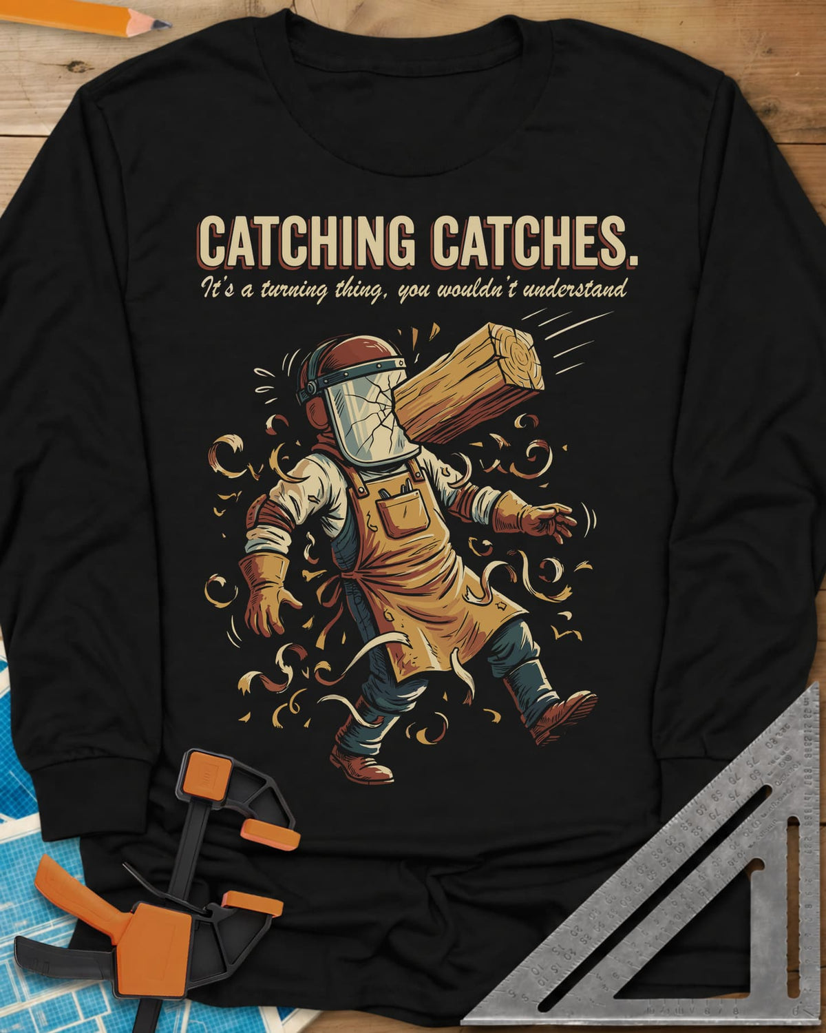 Catching Catches long sleeve shirt in Black, a turner in a cracked face shield and a flying chunk of wood