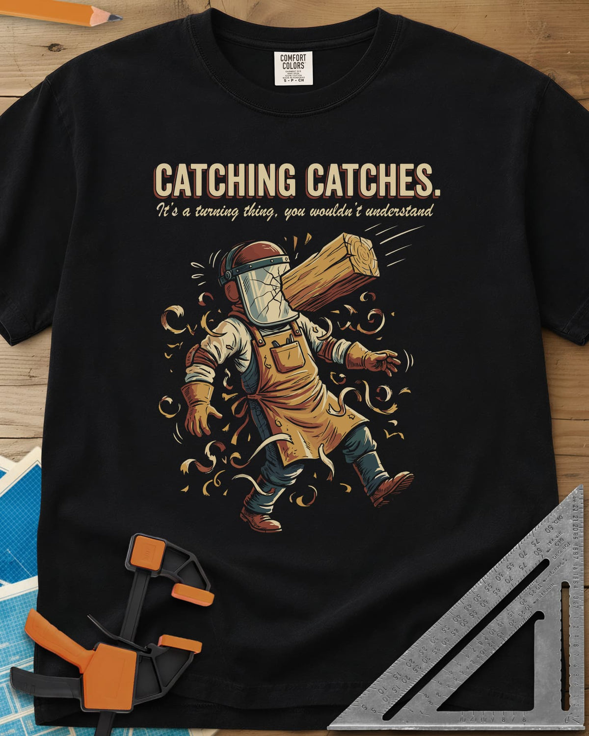 Catching Catches heavyweight tee in Black, a turner in a cracked face shield and a flying chunk of wood