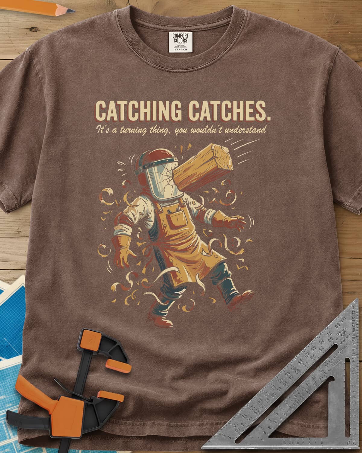 Catching Catches heavyweight tee in Espresso, a turner in a cracked face shield and a flying chunk of wood