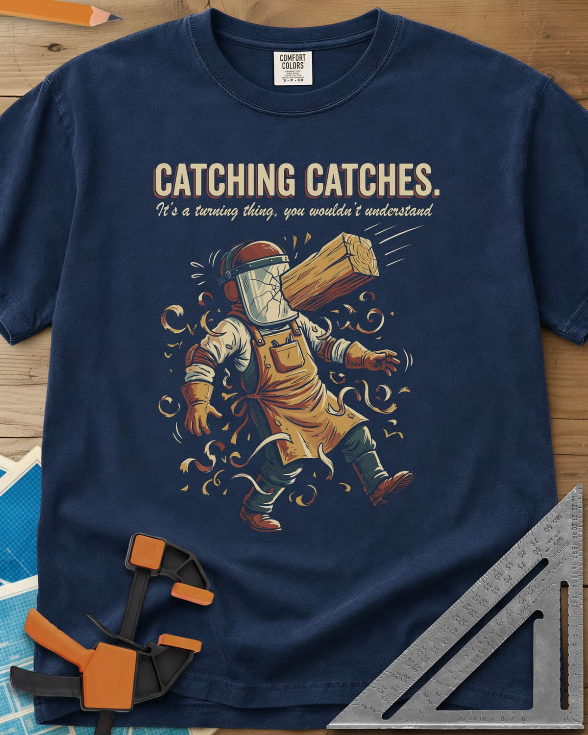 Catching Catches heavyweight tee in Navy, a turner in a cracked face shield and a flying chunk of wood