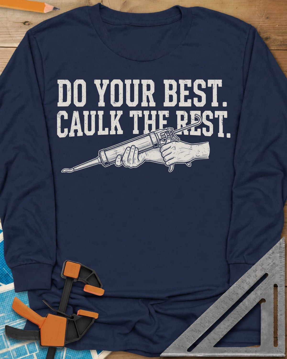 Caulk The Rest long sleeve shirt in Navy, hands working a caulk gun under two lines of block lettering