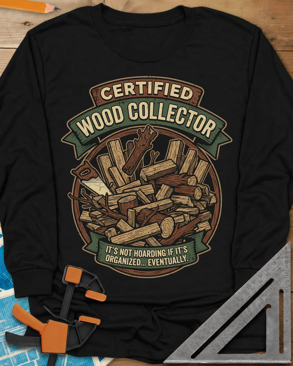 Certified Wood Collector long sleeve shirt in Black, ribbon banners over a heap of logs, offcuts and a handsaw