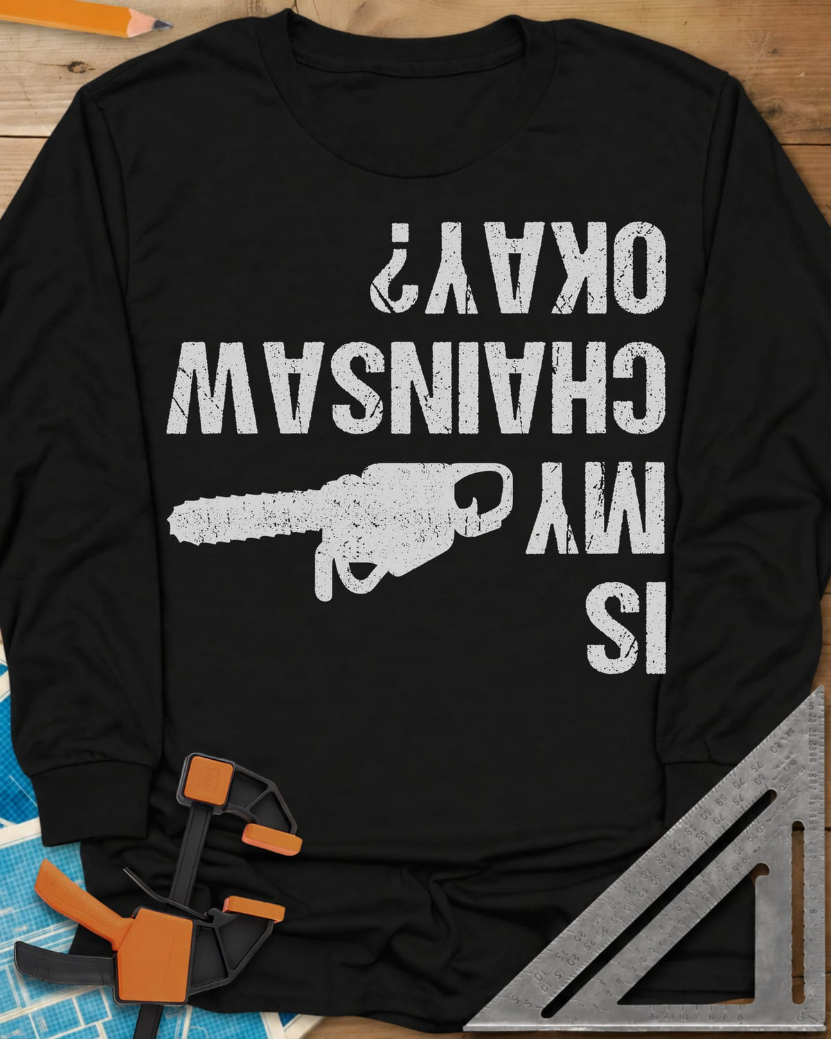 Chainsaw Okay? long sleeve shirt in Black, upside-down distressed lettering beside a chainsaw on its side