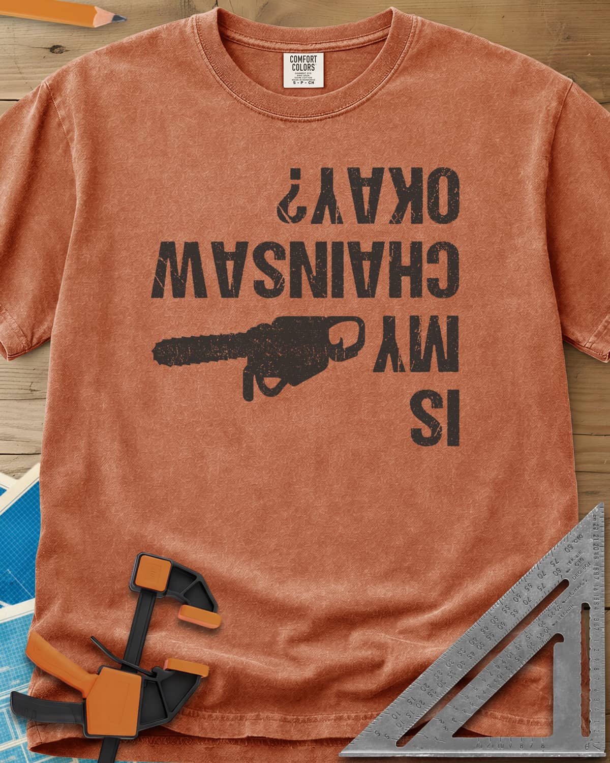 Chainsaw Okay? heavyweight tee in Yam, upside-down distressed lettering beside a chainsaw on its side