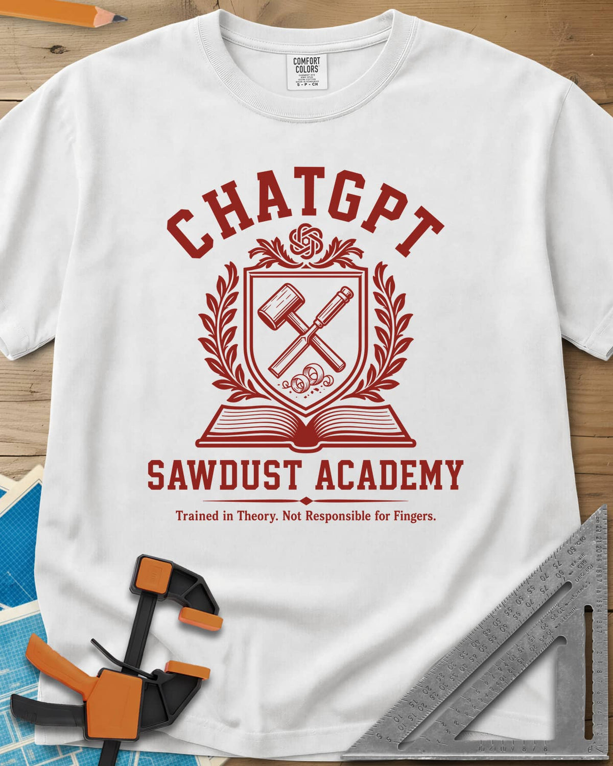 ChatGPT Sawdust Academy heavyweight tee in White, a college crest with a crossed mallet and chisel over an open book