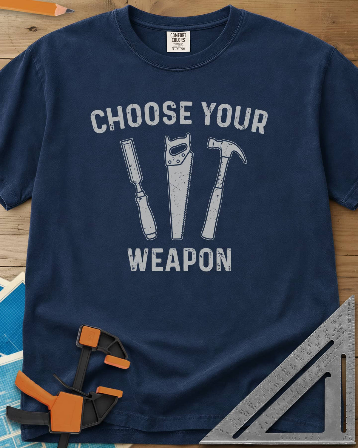 Choose Your Weapon heavyweight tee in Navy, a chisel, a handsaw and a claw hammer standing in a row