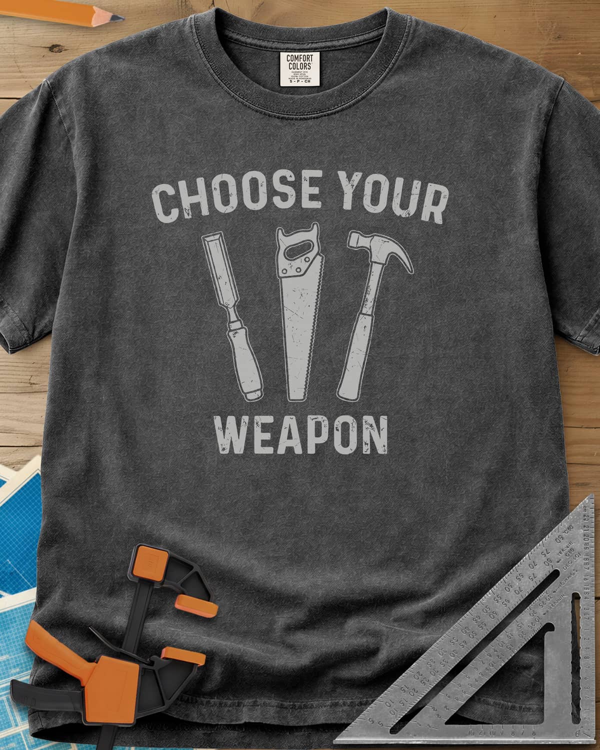 Choose Your Weapon heavyweight tee in Pepper, a chisel, a handsaw and a claw hammer standing in a row