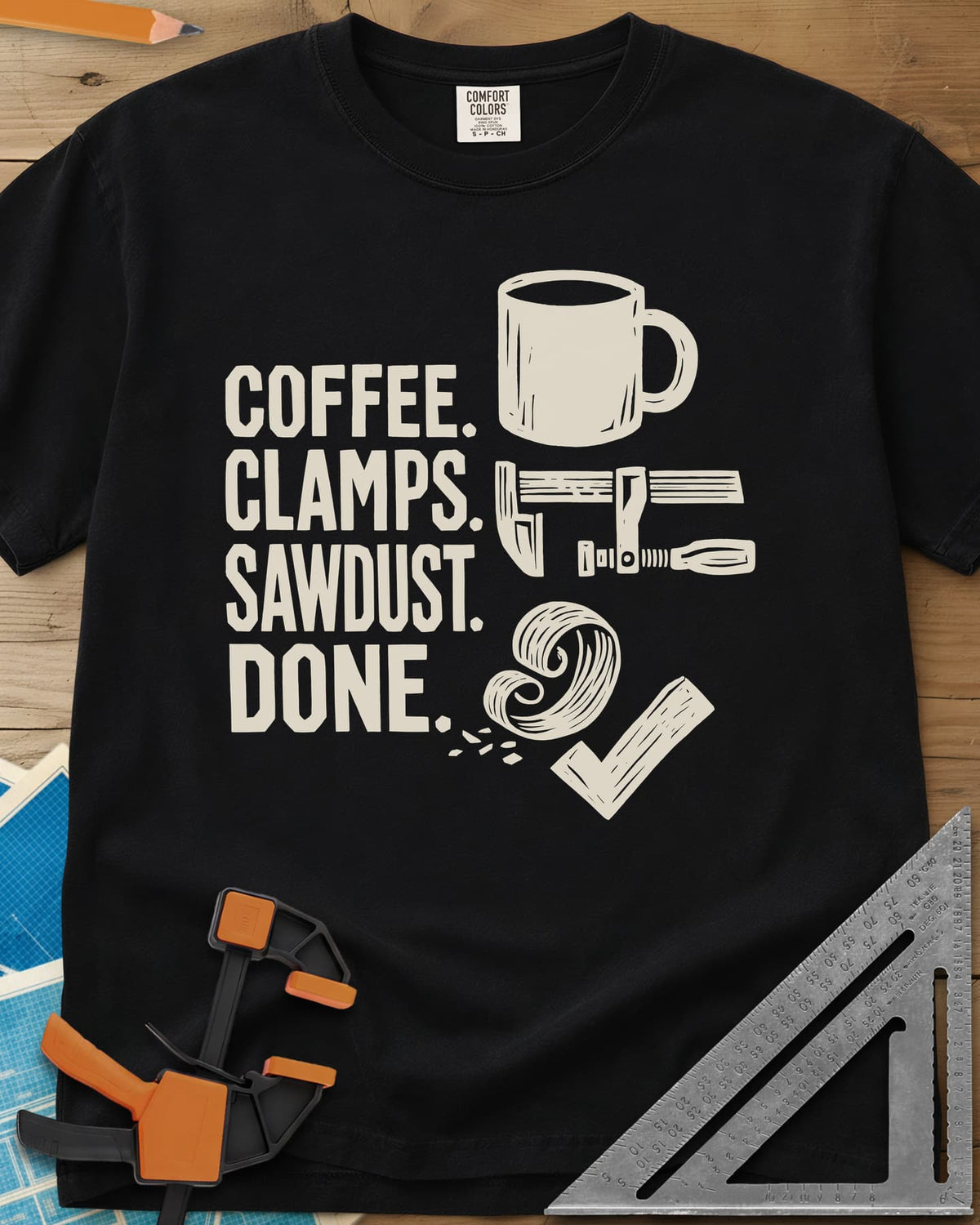 Coffee Clamps heavyweight tee in Black, a mug, a bar clamp, a wood shaving curl and a check mark