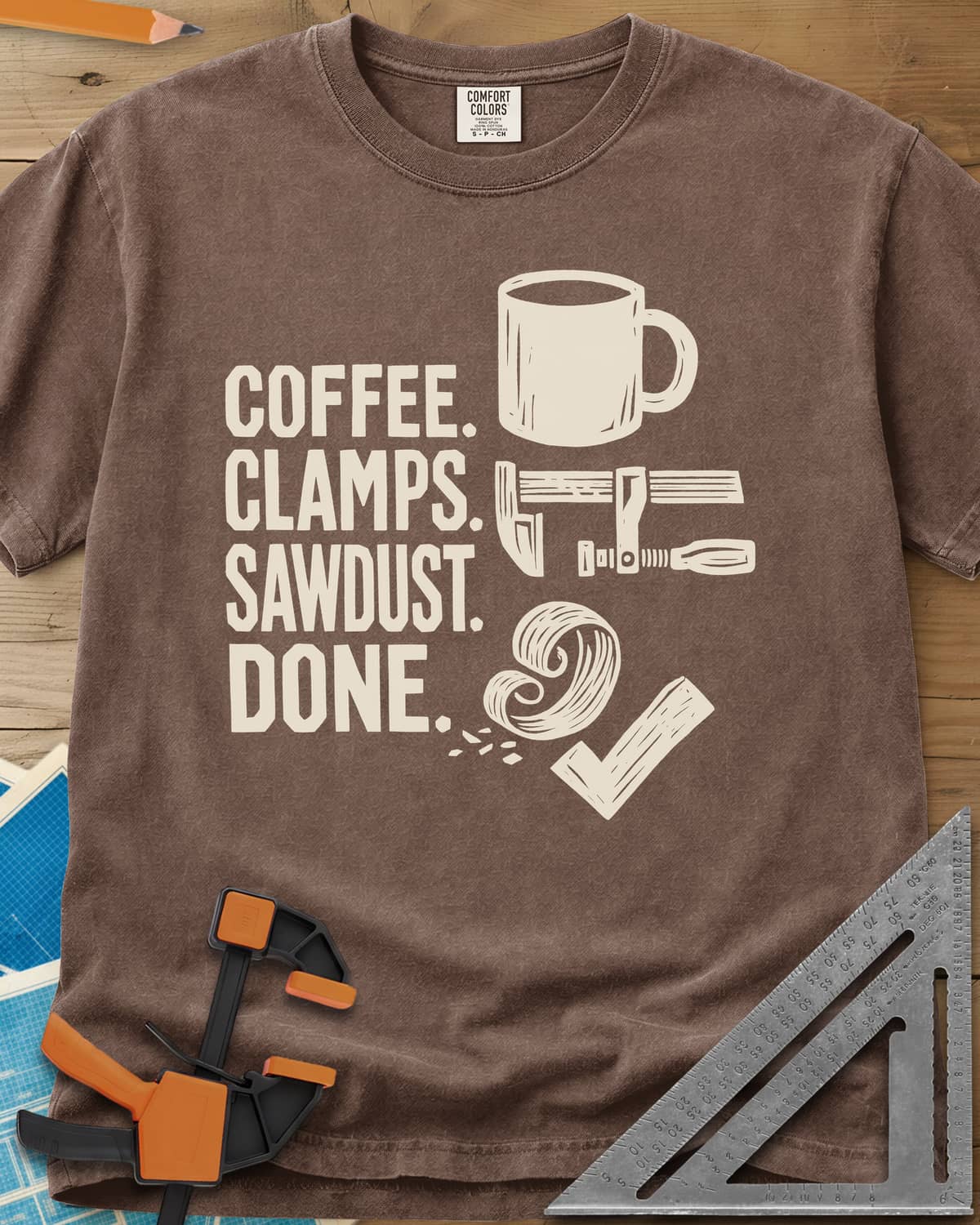 Coffee Clamps heavyweight tee in Espresso, a mug, a bar clamp, a wood shaving curl and a check mark