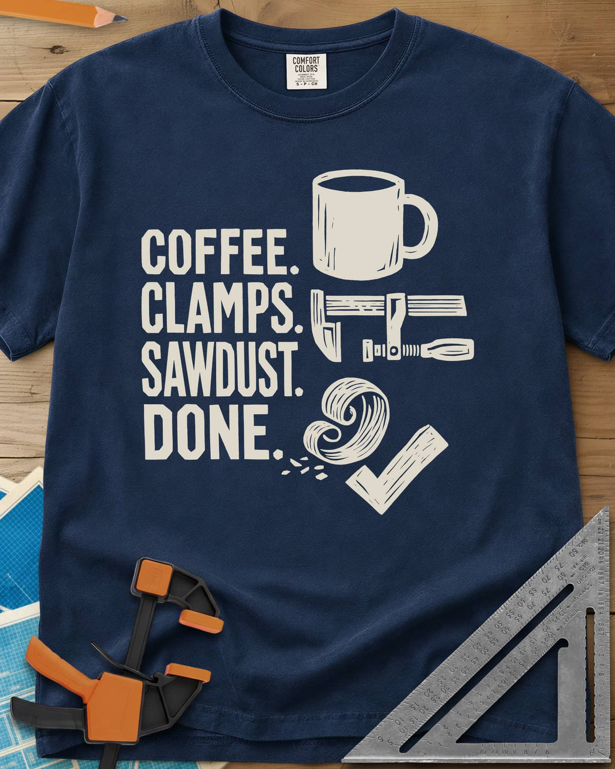 Coffee Clamps heavyweight tee in Navy, a mug, a bar clamp, a wood shaving curl and a check mark