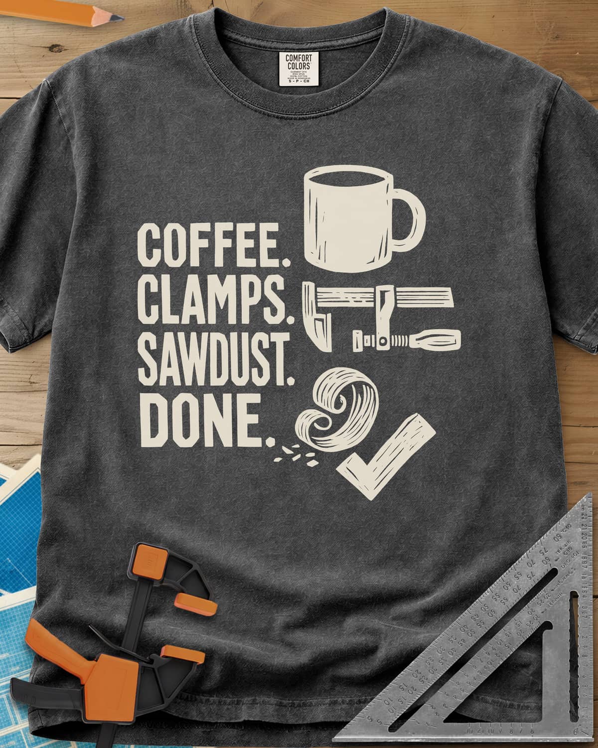 Coffee Clamps heavyweight tee in Pepper, a mug, a bar clamp, a wood shaving curl and a check mark