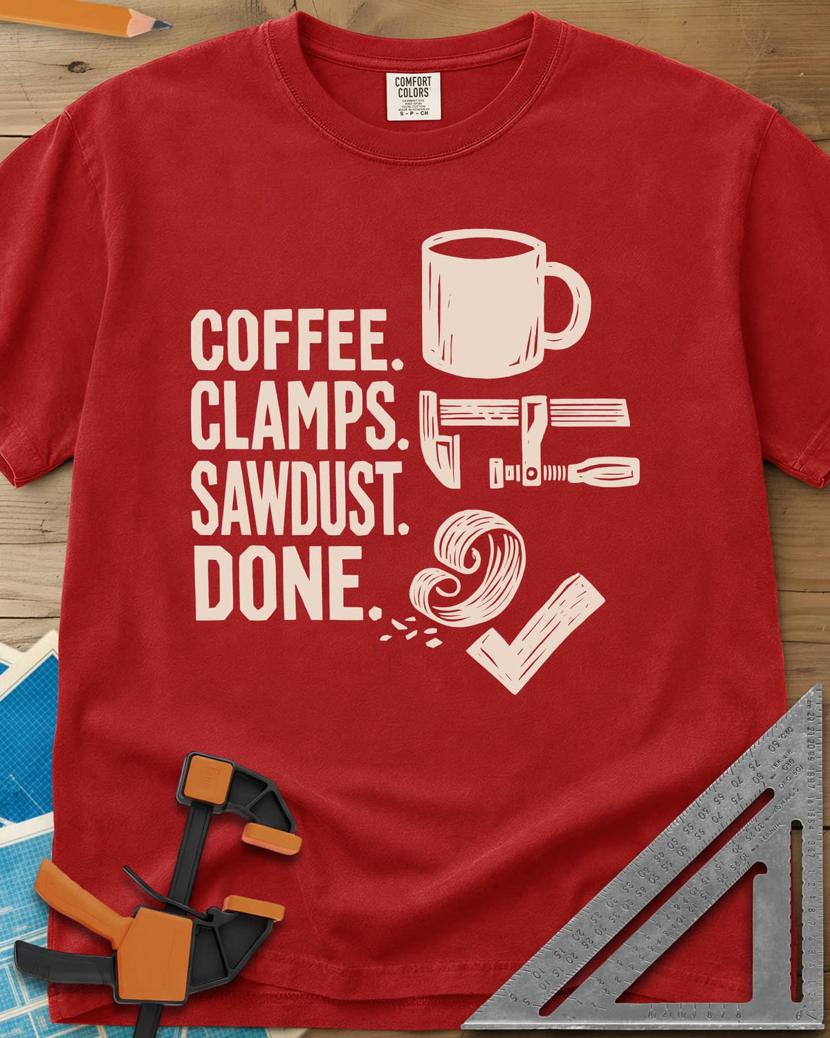 Coffee Clamps heavyweight tee in Red, a mug, a bar clamp, a wood shaving curl and a check mark