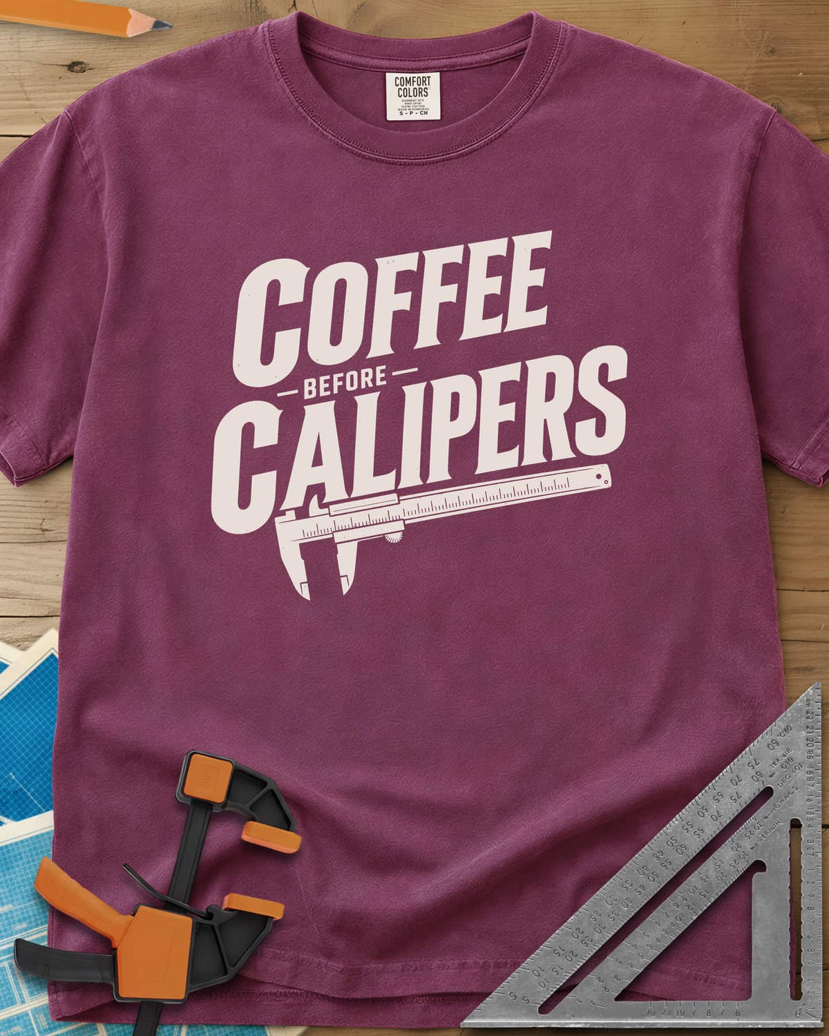 Coffee First heavyweight tee in Berry, bold slanted lettering with an orange vernier caliper below