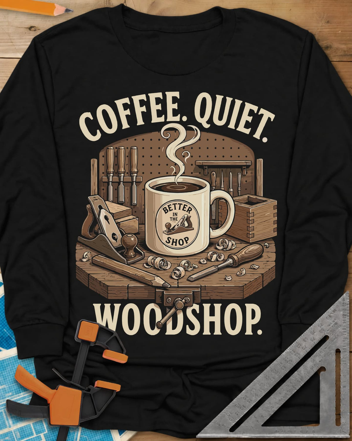 Coffee. Quiet. Woodshop. long sleeve shirt in Black, steaming mug on a workbench with chisels, a plane and wood curls