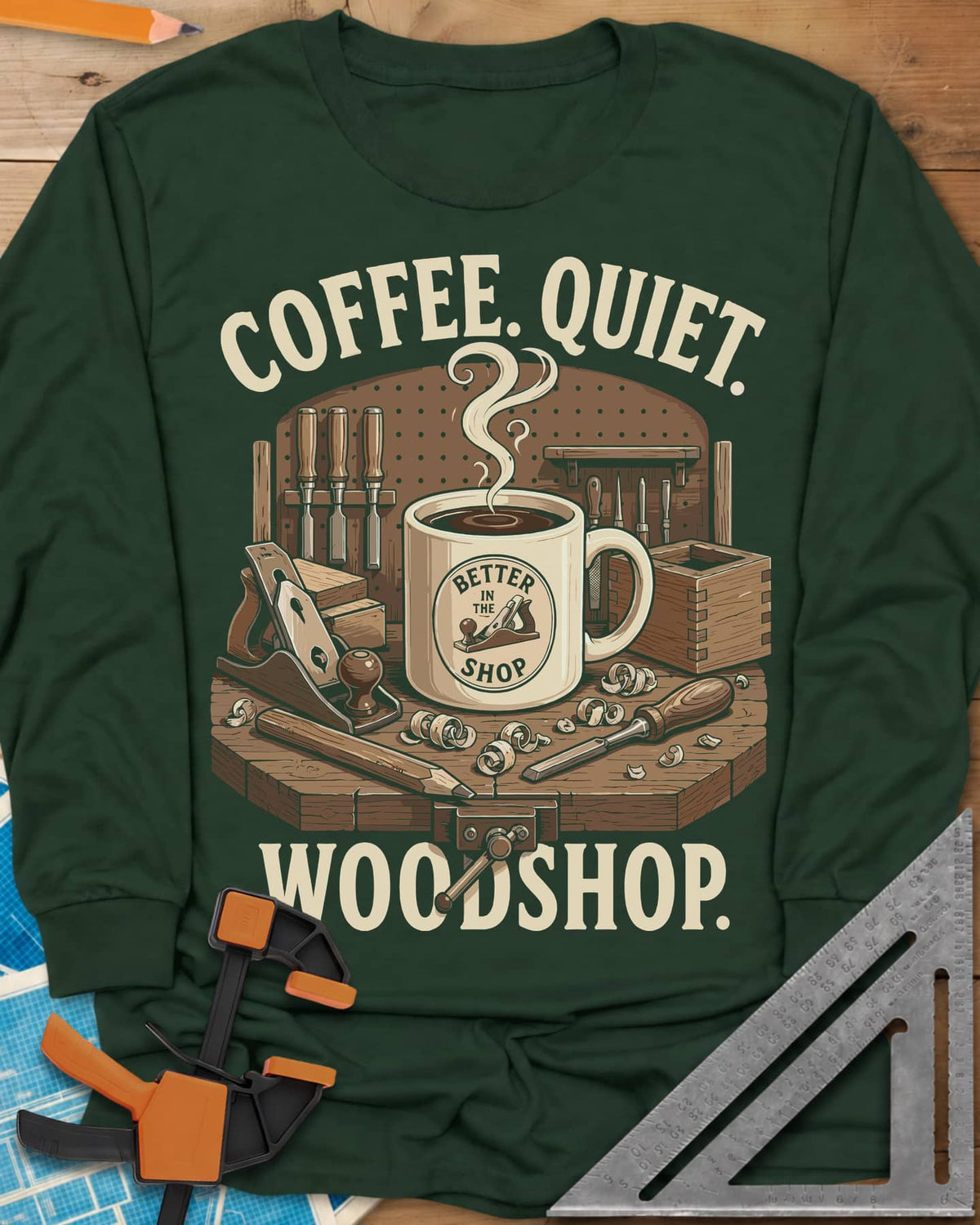 Coffee. Quiet. Woodshop. long sleeve shirt in Forest Green, steaming mug on a workbench with chisels, a plane and wood curls