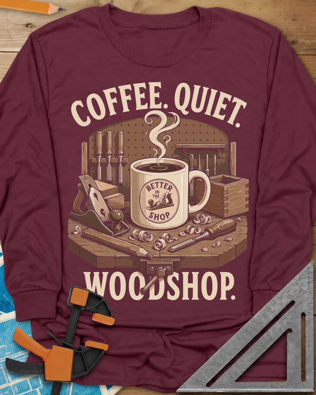 Coffee. Quiet. Woodshop. long sleeve shirt in Maroon, steaming mug on a workbench with chisels, a plane and wood curls