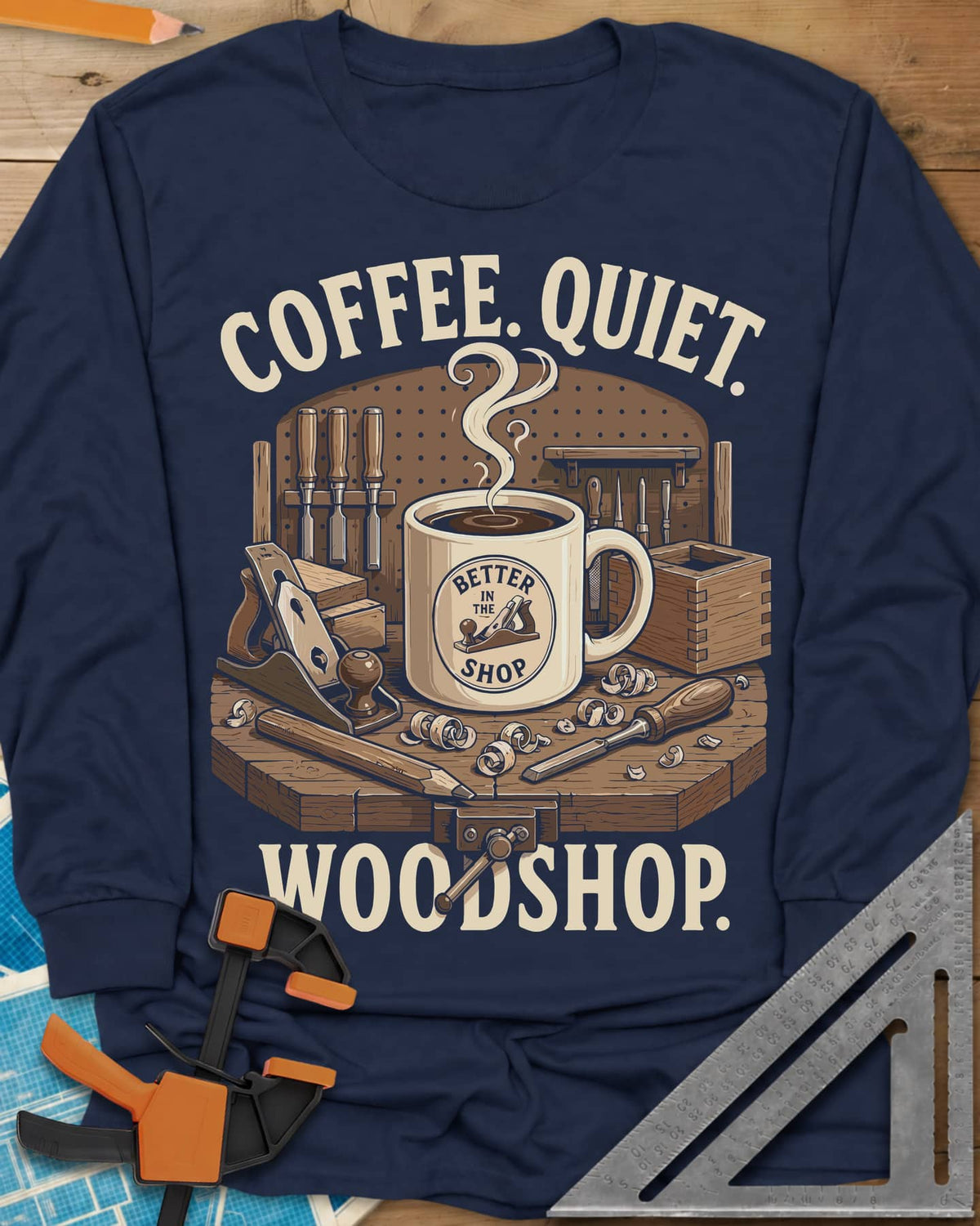 Coffee. Quiet. Woodshop. long sleeve shirt in Navy, steaming mug on a workbench with chisels, a plane and wood curls