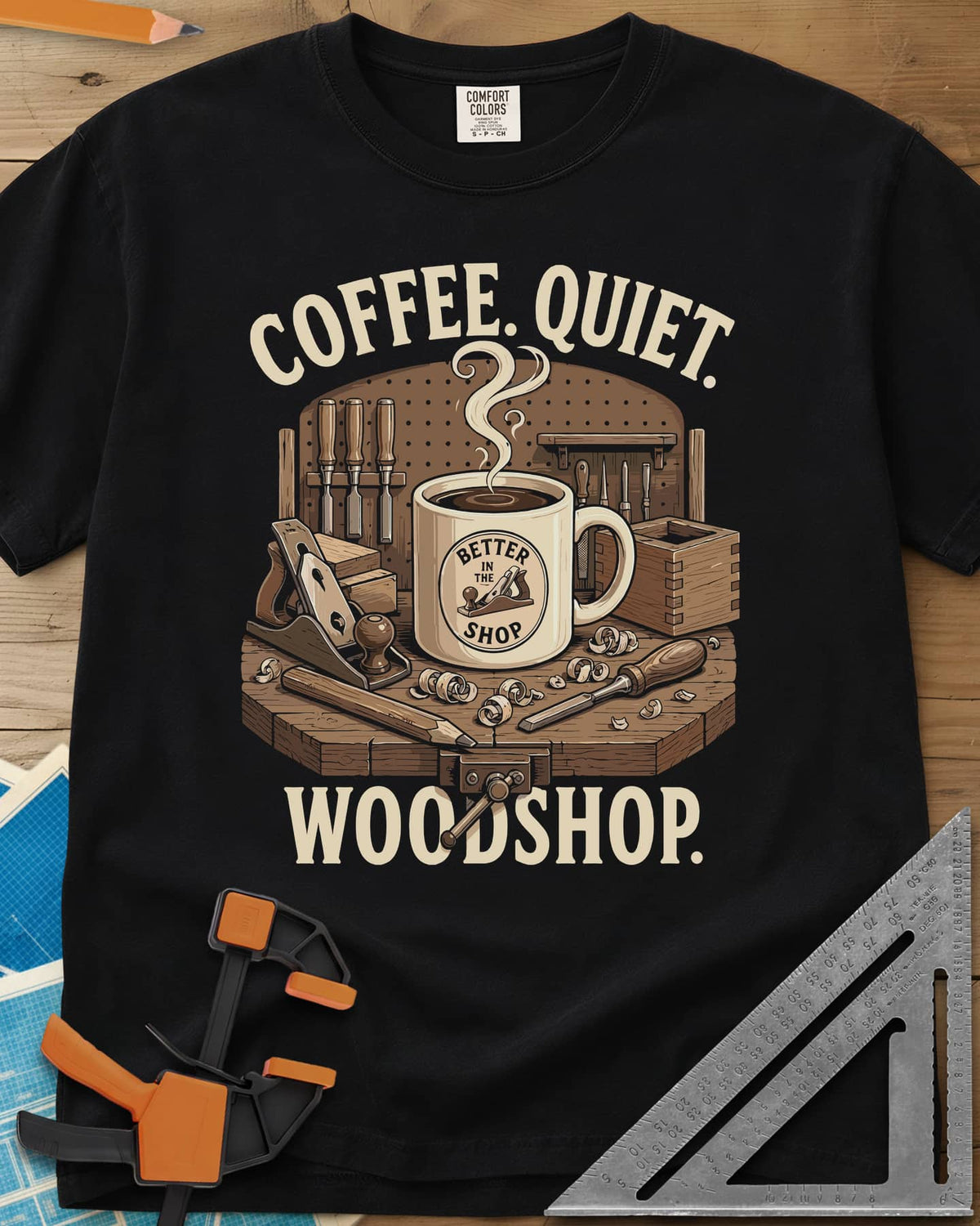 Coffee. Quiet. Woodshop. heavyweight tee in Black, steaming mug on a workbench with chisels, a plane and wood curls