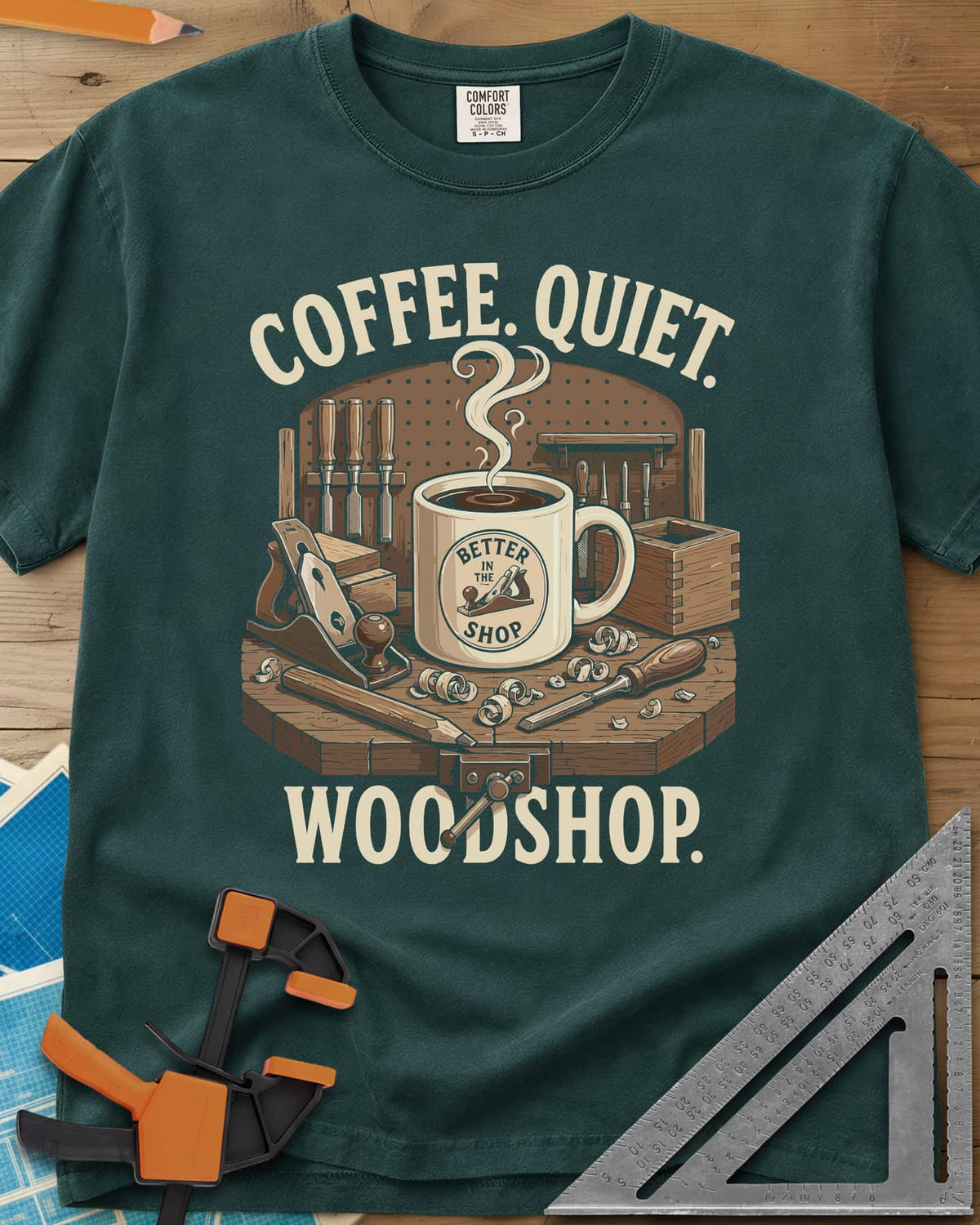Coffee. Quiet. Woodshop. heavyweight tee in Blue Spruce, steaming mug on a workbench with chisels, a plane and wood curls