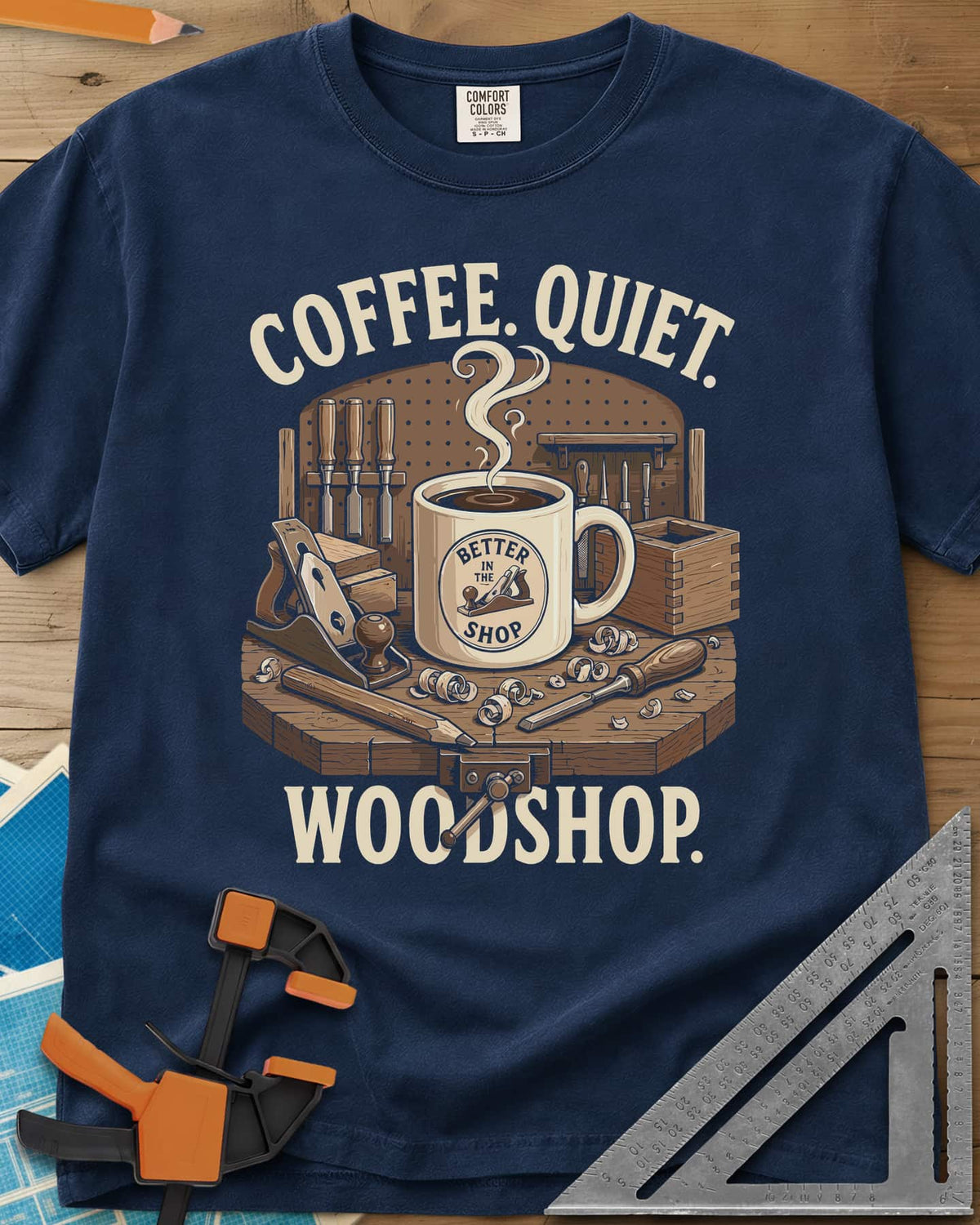 Coffee. Quiet. Woodshop. heavyweight tee in Navy, steaming mug on a workbench with chisels, a plane and wood curls