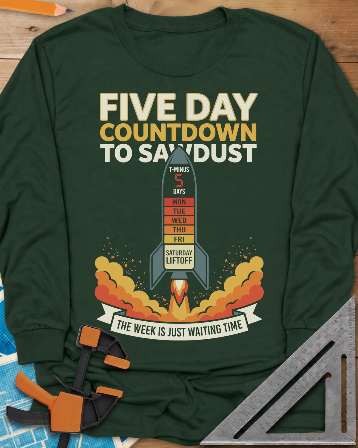 Countdown to Sawdust long sleeve shirt in Forest Green, a rocket with a Monday-to-Saturday countdown on its hull