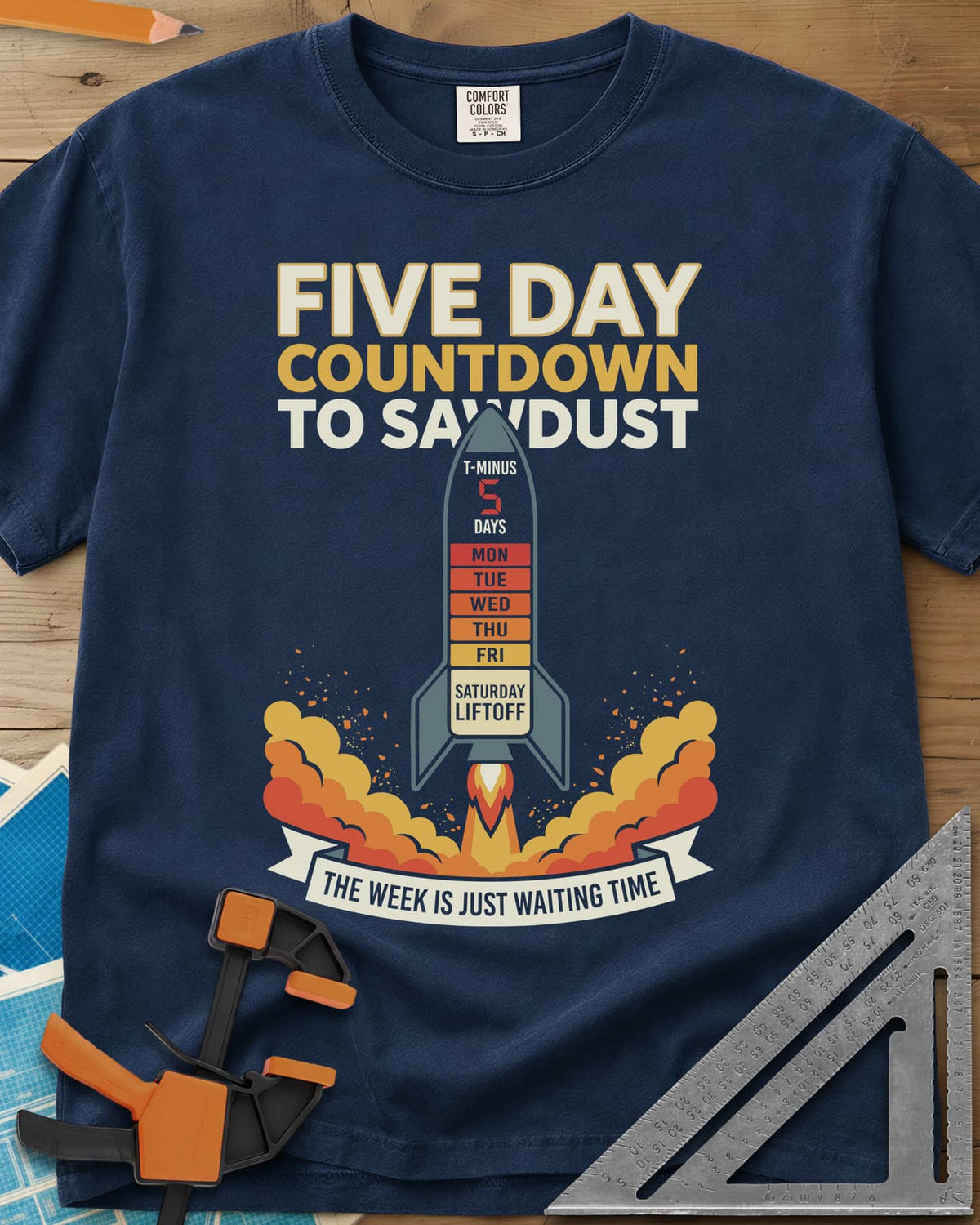 Countdown to Sawdust heavyweight tee in Navy, a rocket with a Monday-to-Saturday countdown on its hull
