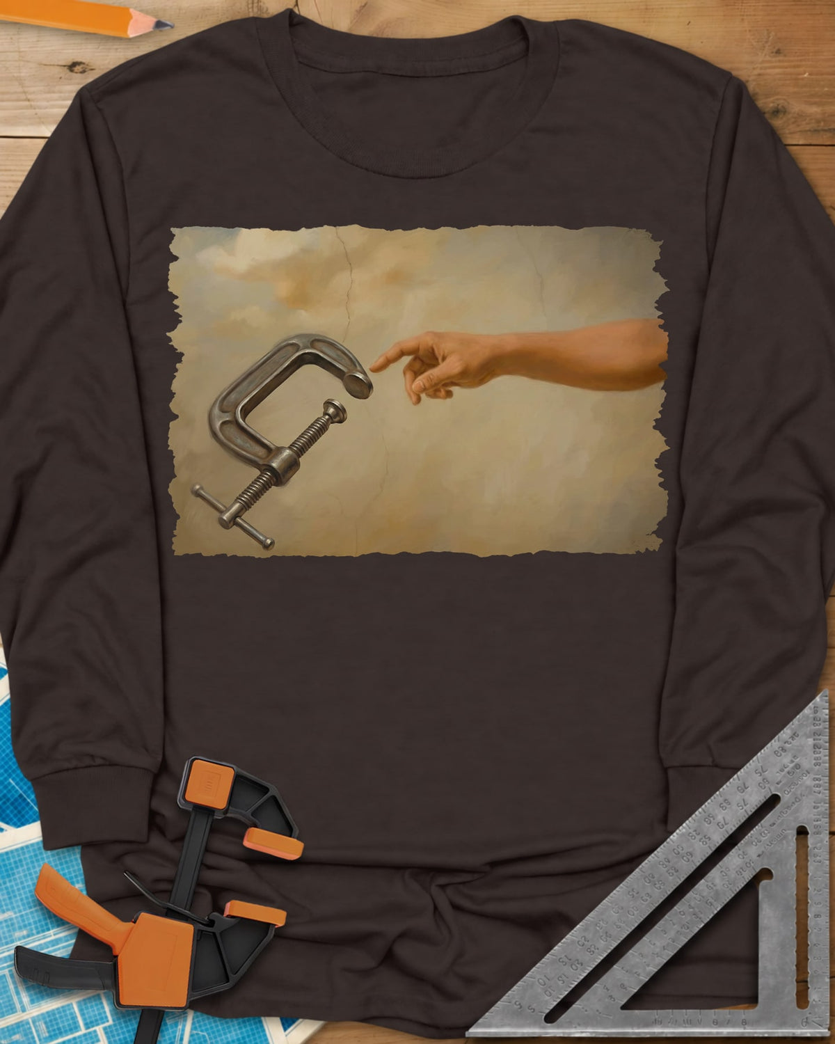 Creation Of The Clamp Woodworking long sleeve shirt in Dark Chocolate, a hand reaching for a C-clamp in an aged fresco style