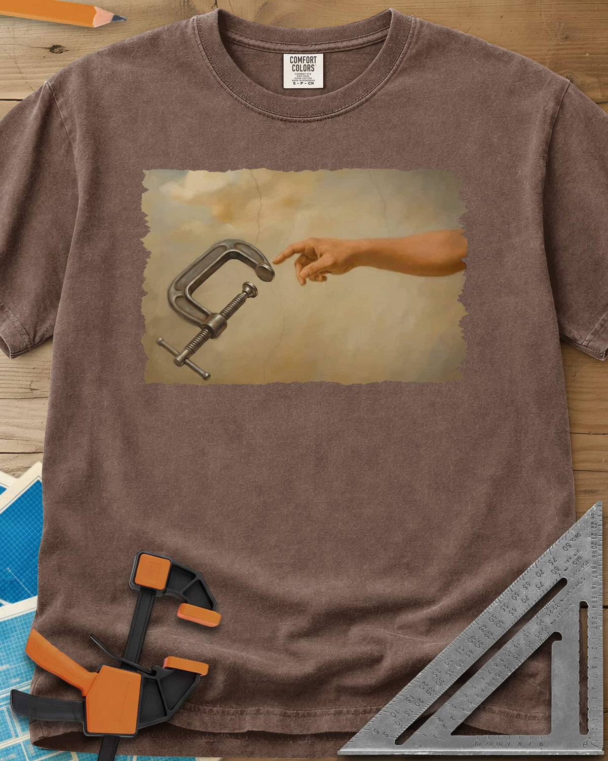 Creation Of The Clamp Woodworking heavyweight tee in Espresso, a hand reaching for a C-clamp in an aged fresco style