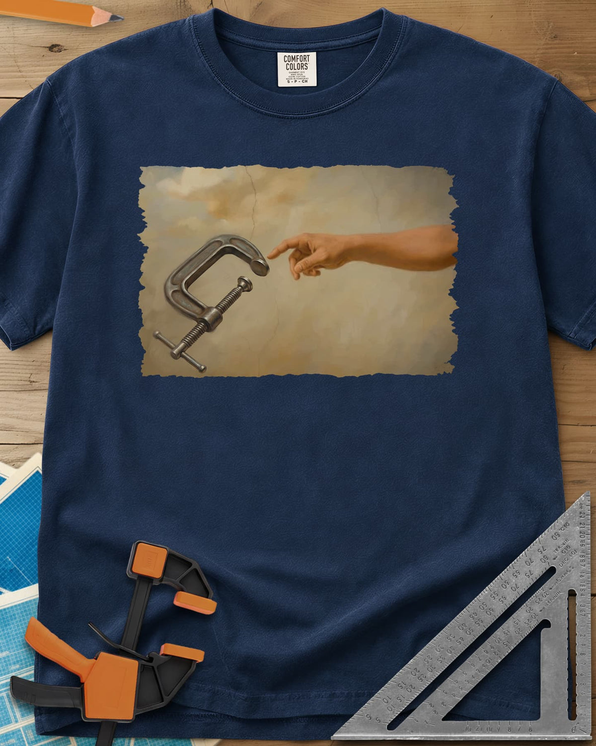 Creation Of The Clamp Woodworking heavyweight tee in Navy, a hand reaching for a C-clamp in an aged fresco style