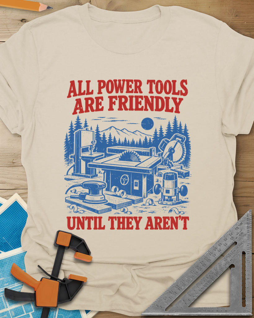 Friendly Tools t-shirt in Sand, a table saw, bandsaw, miter saw, sander and router in a forest