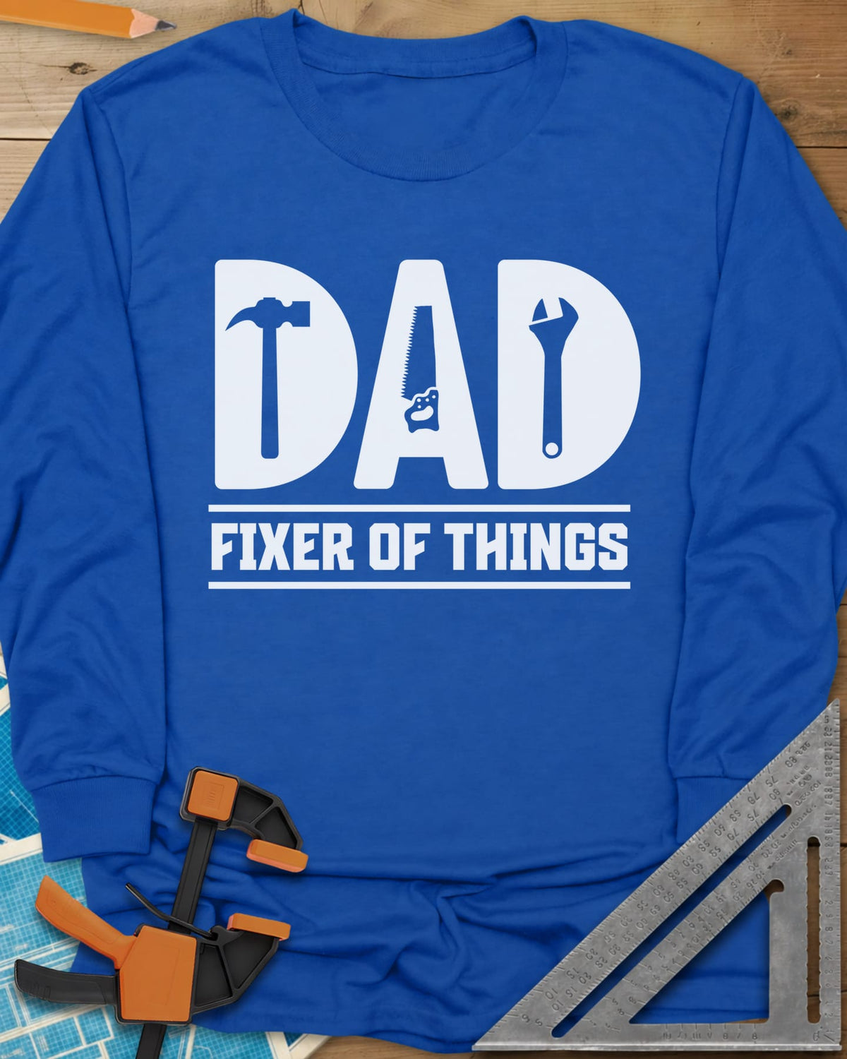 Dad, Fixer of All Things long sleeve shirt in Royal, big letters spelling DAD with a hammer, saw and wrench cut in