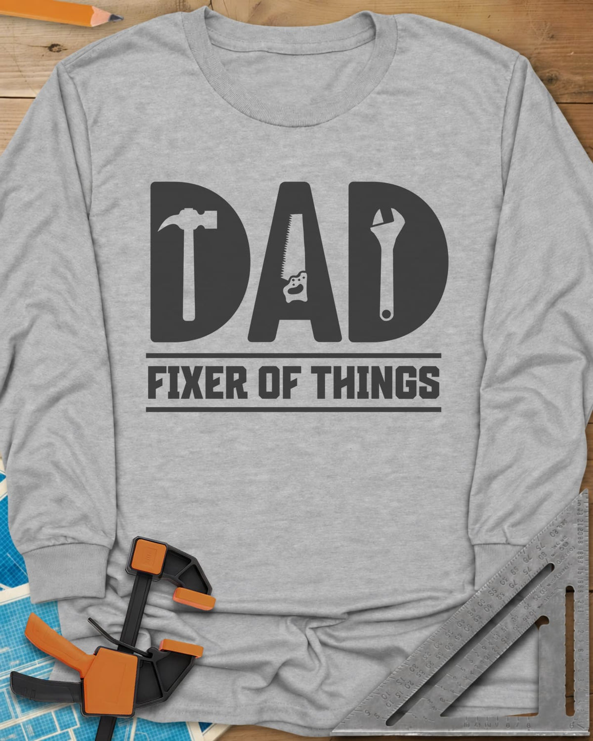 Dad, Fixer of All Things long sleeve shirt in Sport Grey, big letters spelling DAD with a hammer, saw and wrench cut in