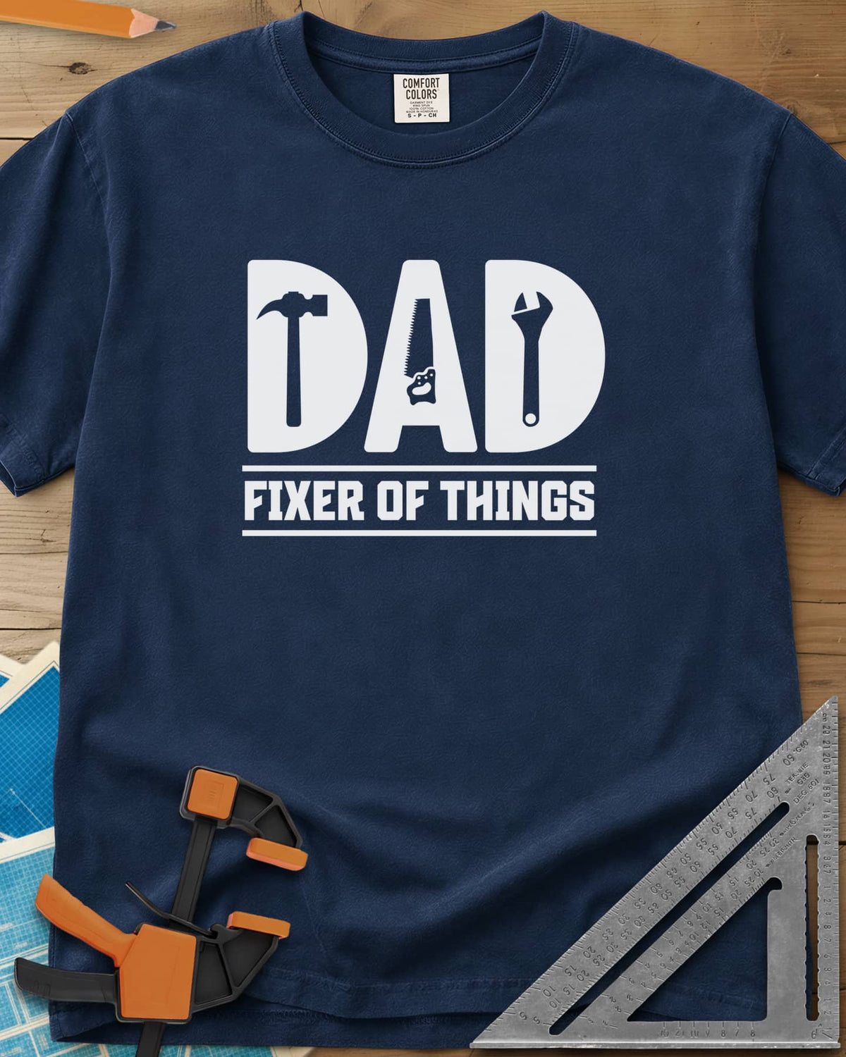 Dad, Fixer of All Things heavyweight tee in Navy, big letters spelling DAD with a hammer, saw and wrench cut in