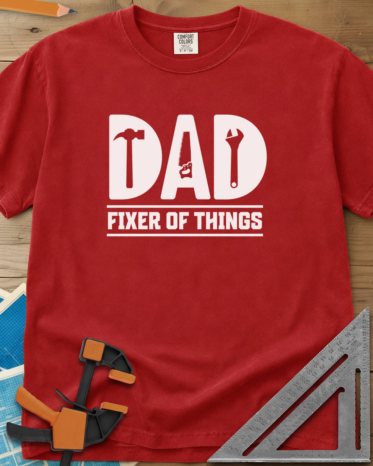 Dad, Fixer of All Things heavyweight tee in Red, big letters spelling DAD with a hammer, saw and wrench cut in