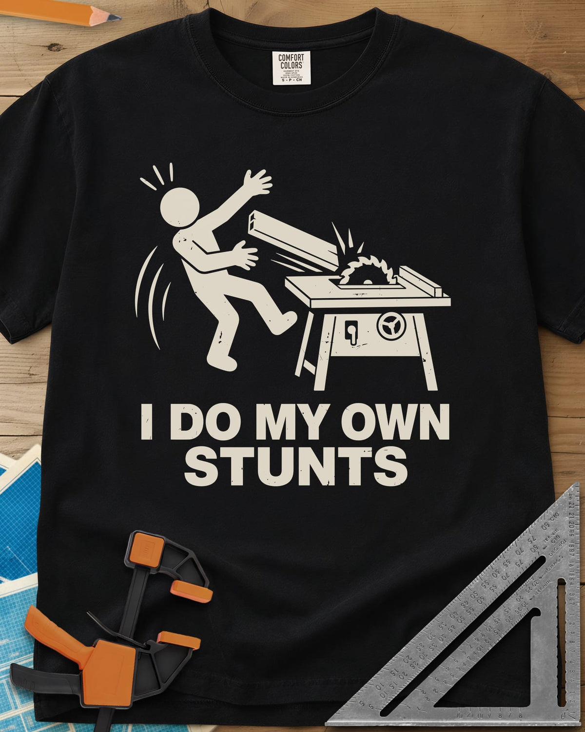 DIY Stunts heavyweight tee in Black, a stick figure leaning back as a board flies off a table saw