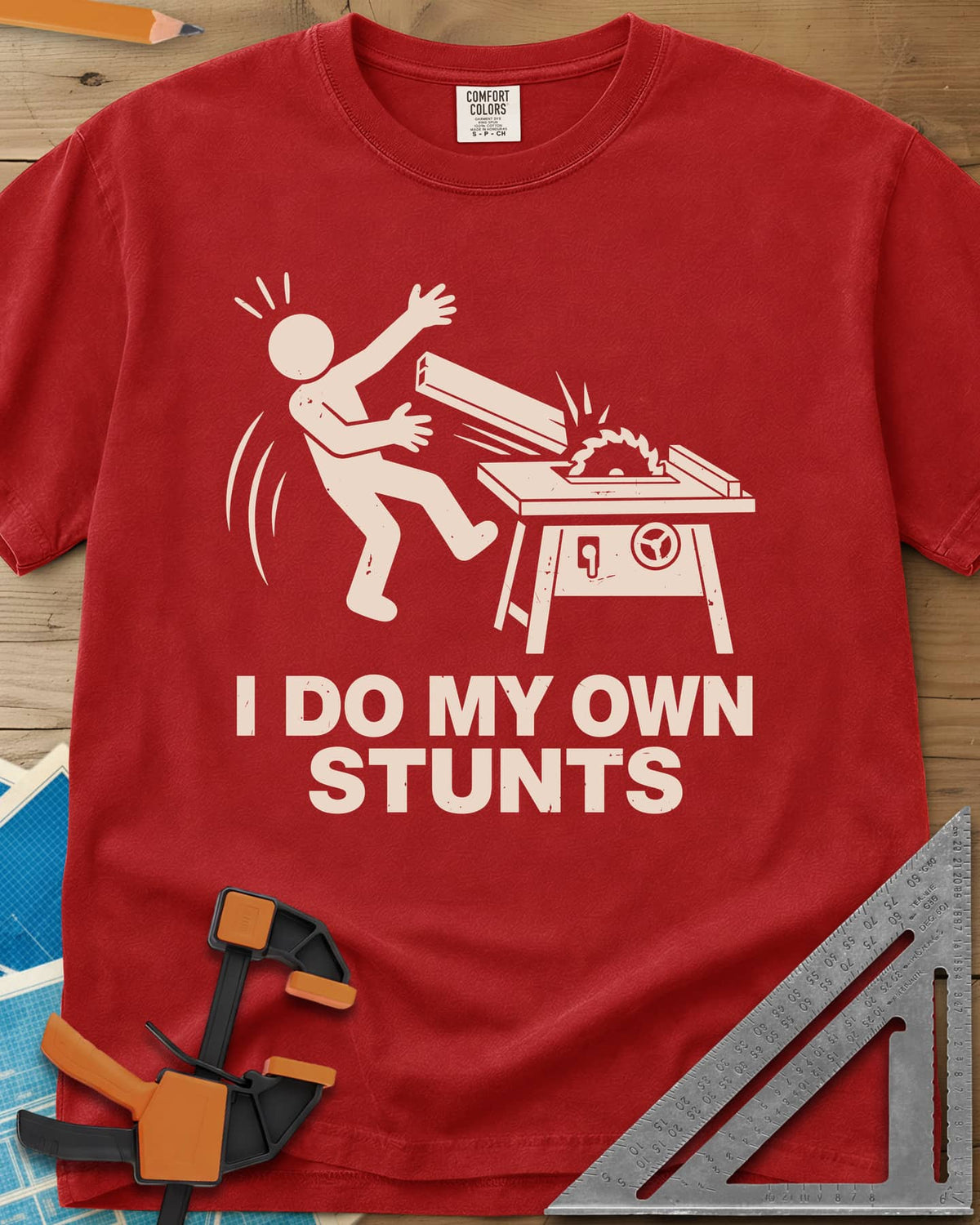 DIY Stunts heavyweight tee in Red, a stick figure leaning back as a board flies off a table saw