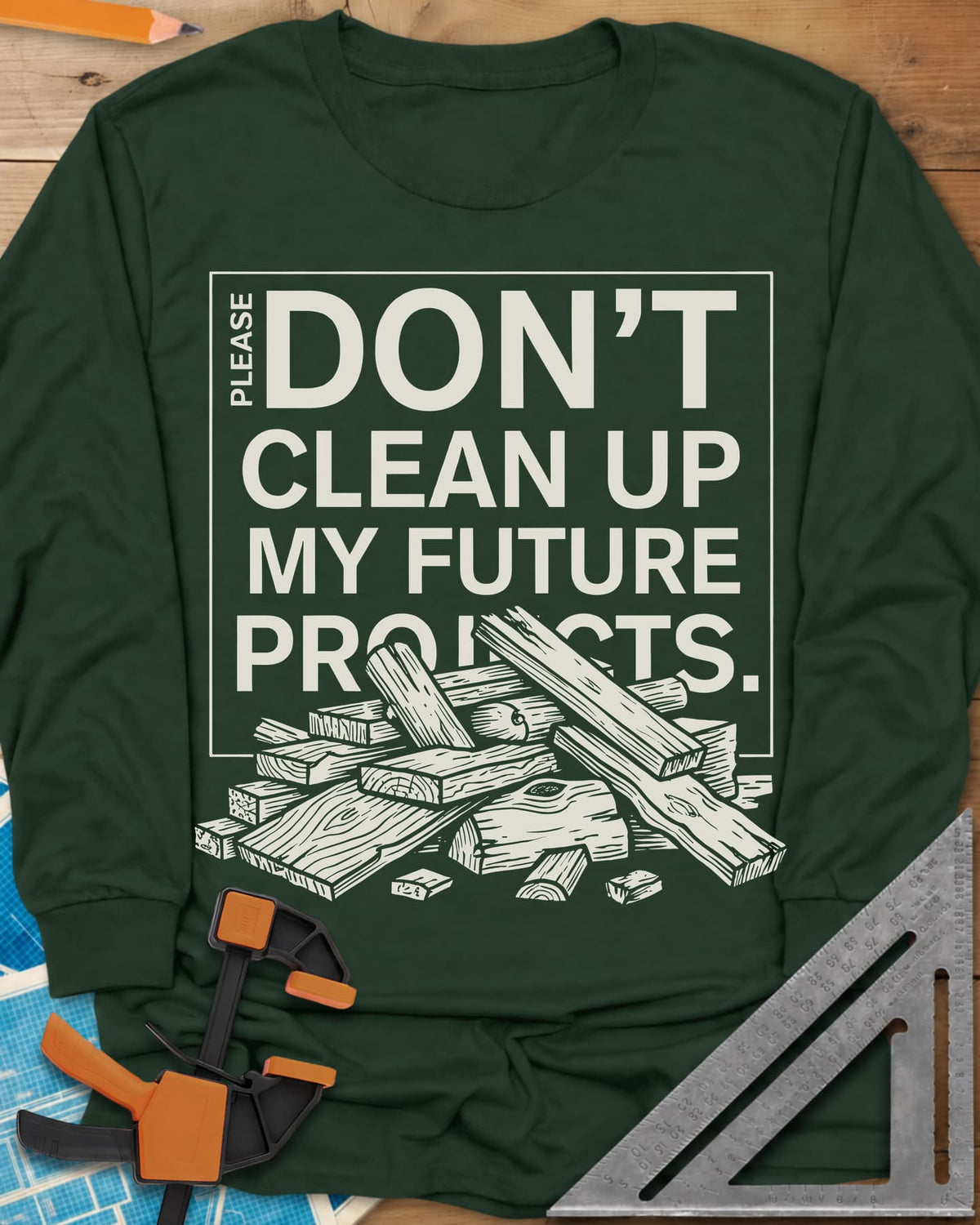 Don't Clean Up My Future Projects long sleeve shirt in Forest Green, a boxed plea with a pile of boards and offcuts below