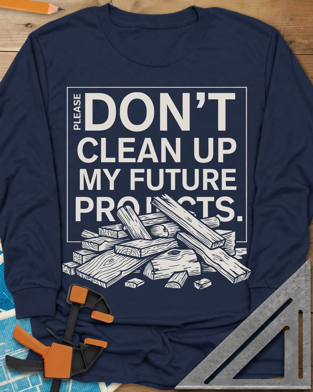 Don't Clean Up My Future Projects long sleeve shirt in Navy, a boxed plea with a pile of boards and offcuts below